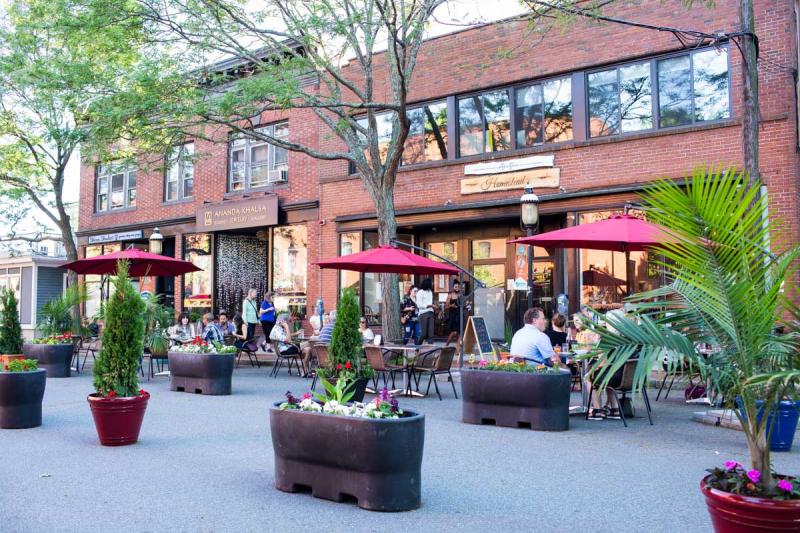 Three tables of people eating outside in downtown Northampton.