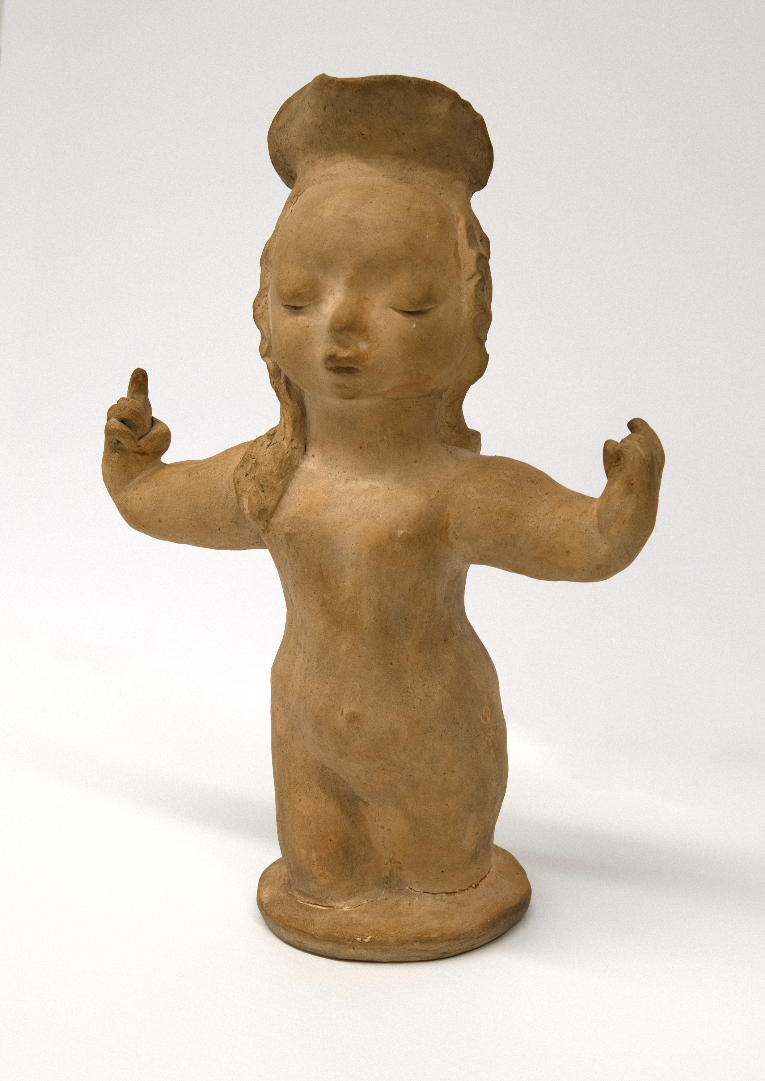 Sculpture of girl with hat holding arms up. 