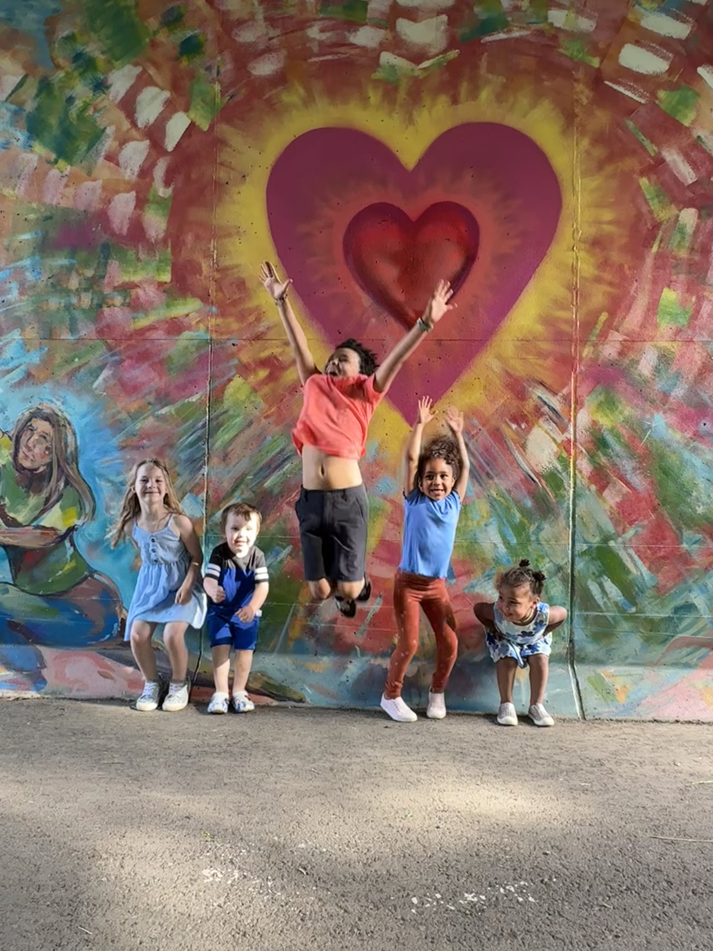 Photograph of heart mural with kids. 
