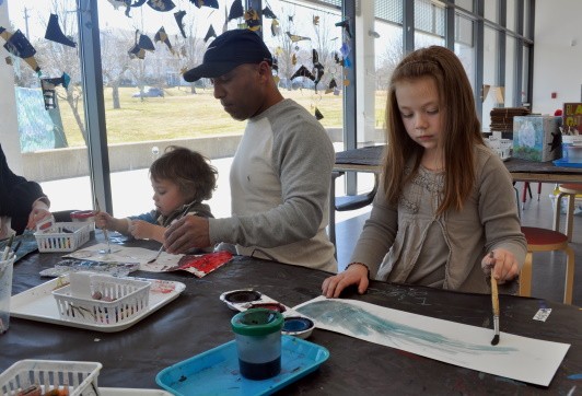 A family watercolor painting together in the Art Studio.
