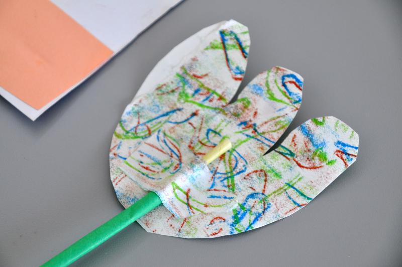 Cut-out collage paper attached to straw with another paper