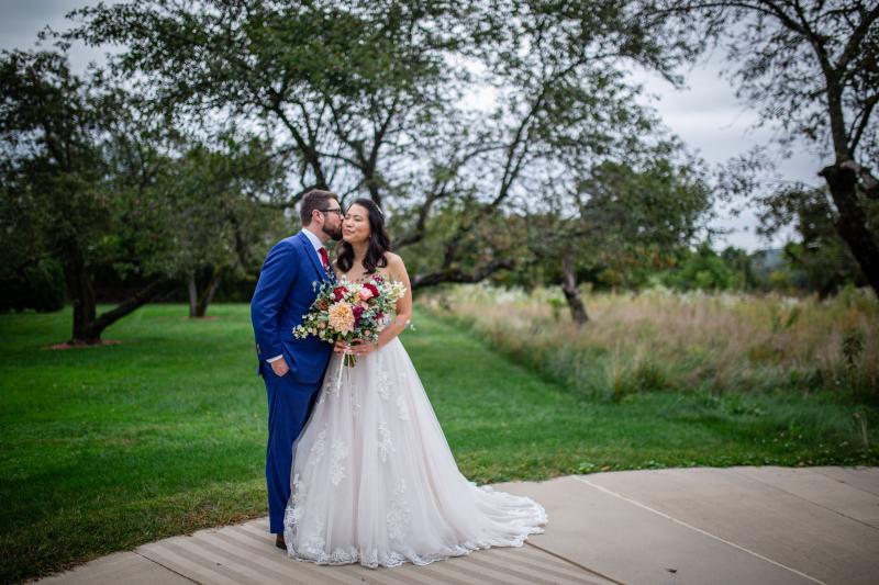 A wedding couple standing together outside
