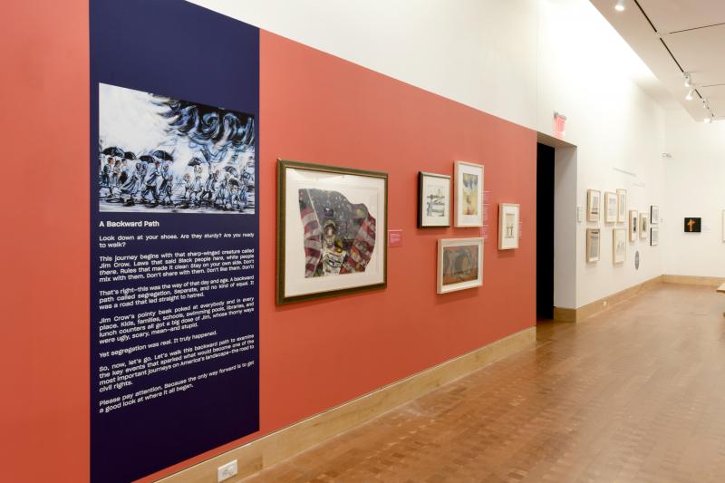 Installation image showing long wall with framed art.