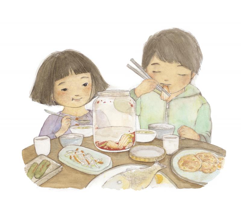 Two children eating kimchi at table.