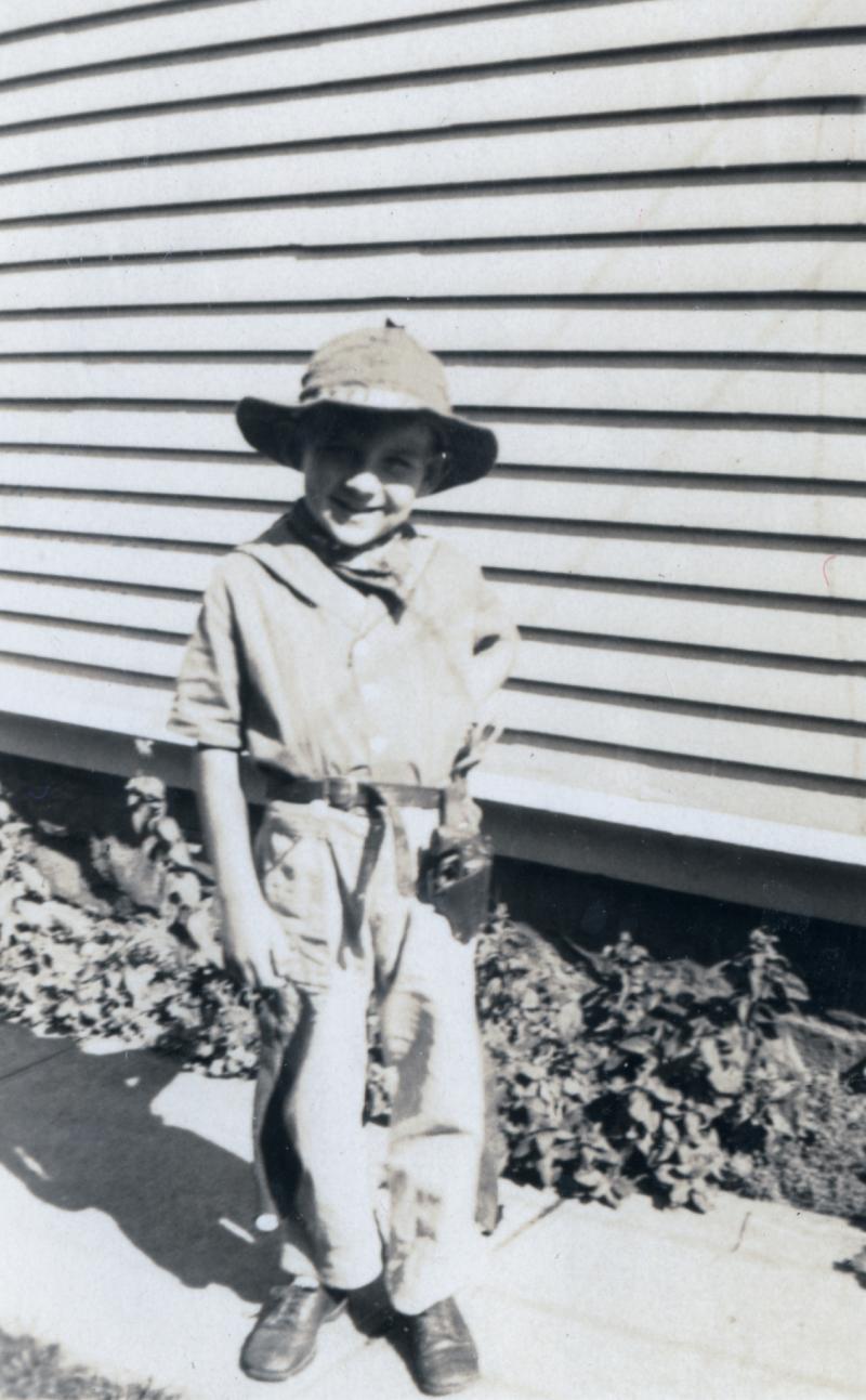 black and white photograph of of boy dresses as a cowboy