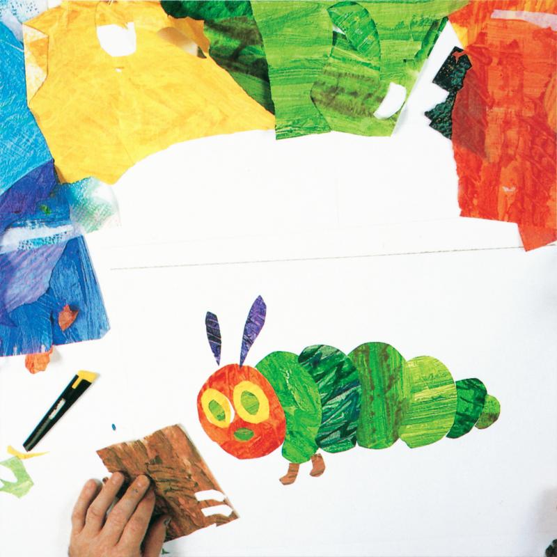 caterpillar collage almost complete with hand holding brown painted tissue paper from which two leg shapes were cut and placed below one of the caterpillars green body