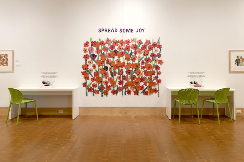 Installation image showing activity tables and poppy flower graphic.