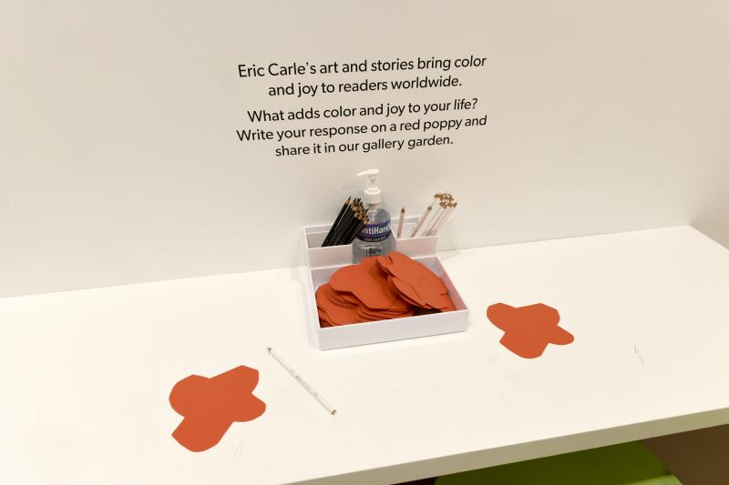 Installation image showing red poppy activity paper with prompt: &quot;What adds color and joy to your life?&quot;