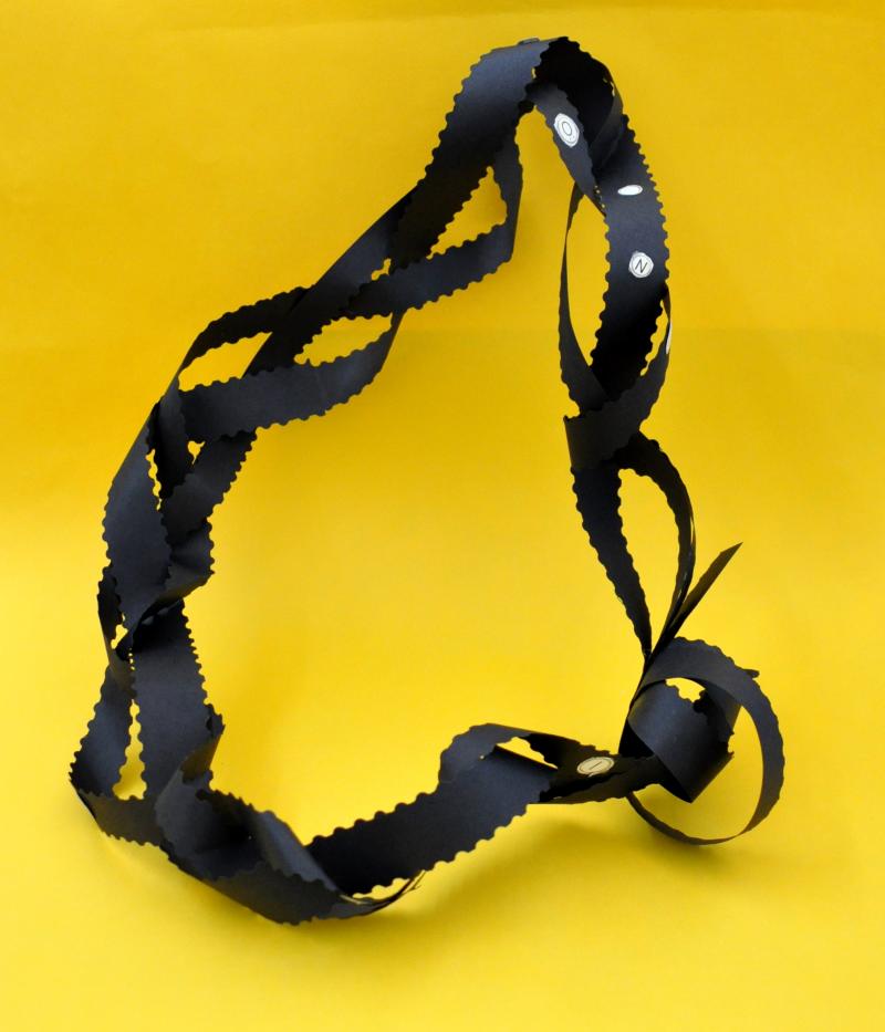 Necklace made with braided strands of cut paper.