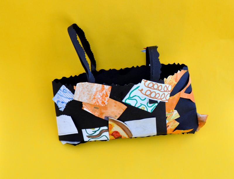 Bag made from paper with two loop handles and sticker embellishments.