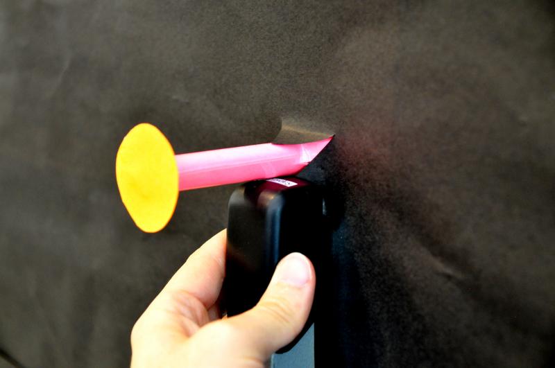 Paper peg attached to a bulletin board with a stapler.