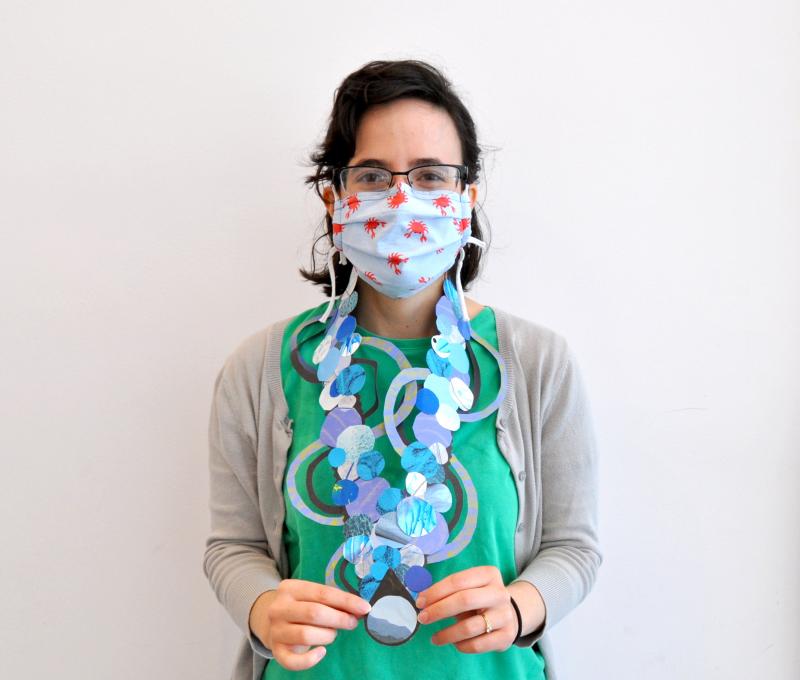 Art Studio team member wearing collage paper necklace.