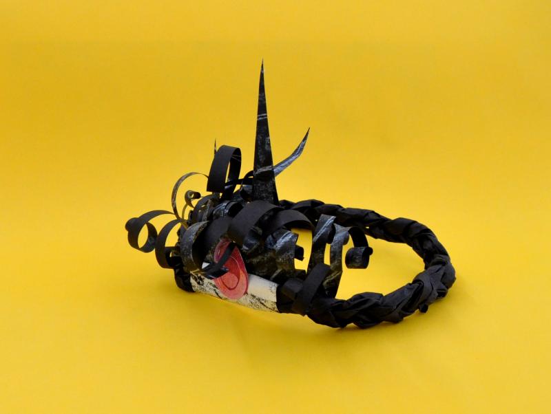 Collage paper crown with braided band and curled paper front.