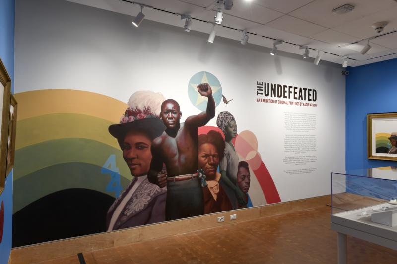 Photograph of paintings hanging on wall in gallery