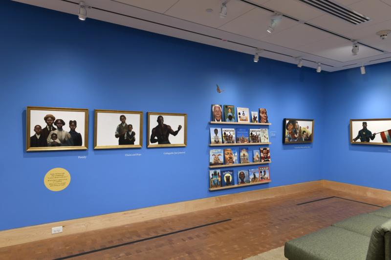 Photograph of paintings hanging on wall in gallery