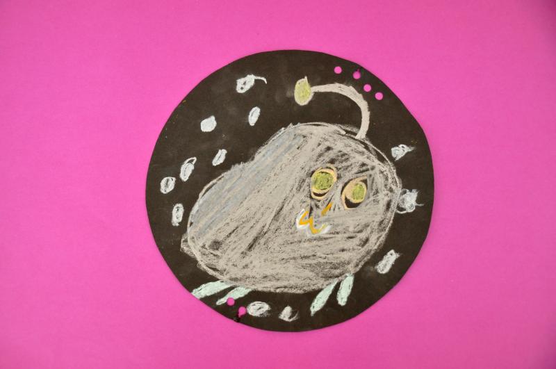 A deep-sea creature made with grey and yellow oil pastels.
