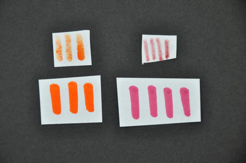 Dried-marker marks on the top papers, and bold, vibrant marks below them after they were revived.