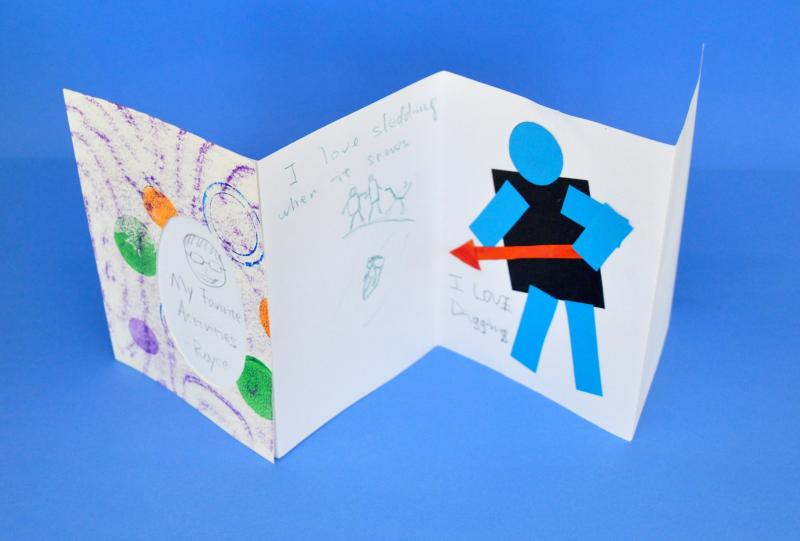 An accordion fold book with the title "My Favorite Activities" and words and images about sledding and digging.