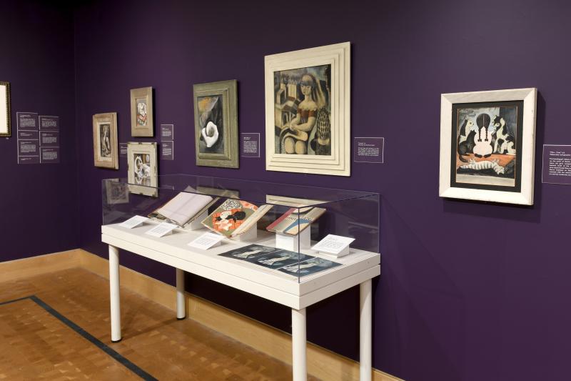 Installation image showing art framed on walls.