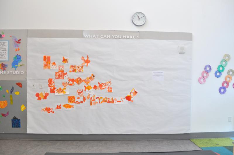 A wall with orange collages installed onto it.