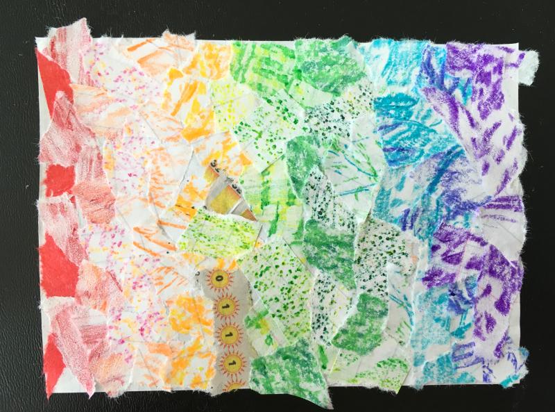 A rainbow collage made from small scraps of torn paper.