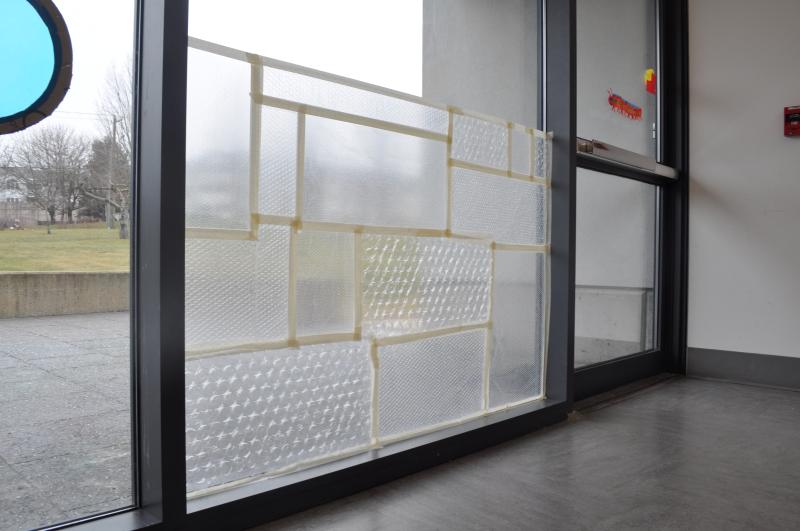 Bubble wrap sheets of different sizes taped to the studio window.