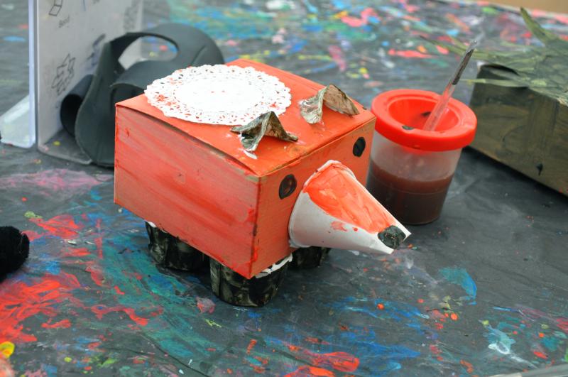 A red fox sculpture with curved cups for ears, a cone for a nose, and cups for feet.