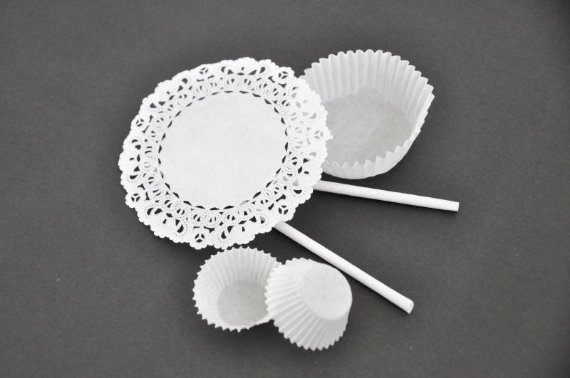 A paper doily, paper cupcake liners, and two paper straws.