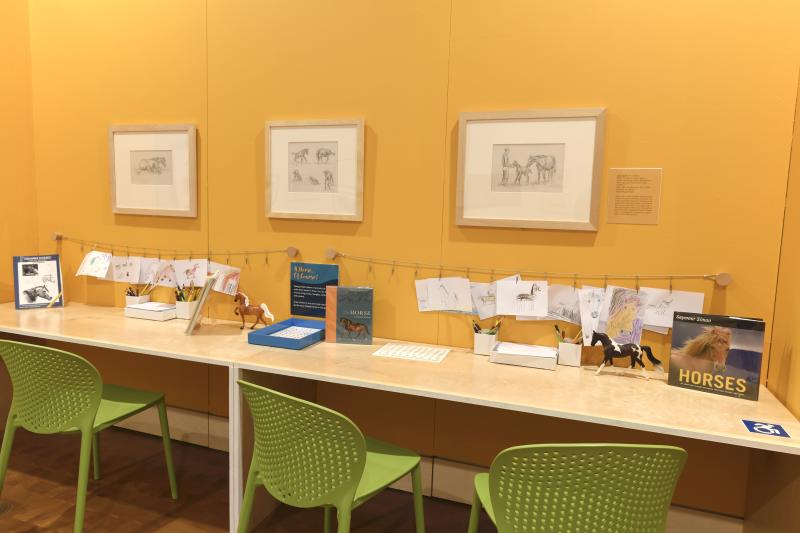 Photograph of installation showing art on walls.
