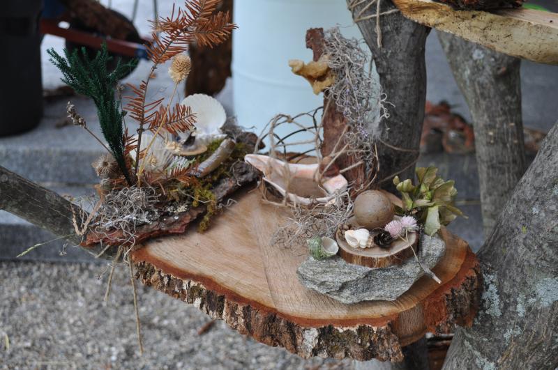 Handmade fairy houses made out of assortments of natural materials including seashells, bark, and grasses.