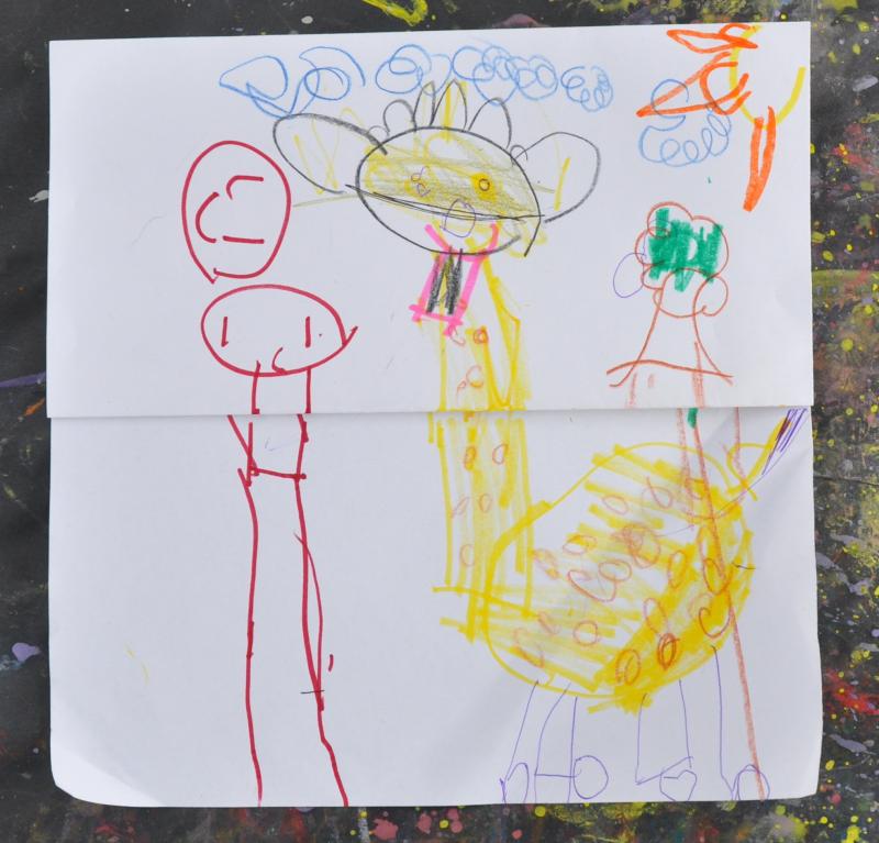 A child's folded flipflap drawing of a giraffe and friends