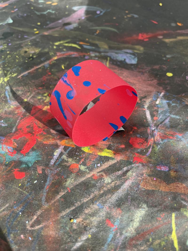 Red strip of paper looped into a cylinder.