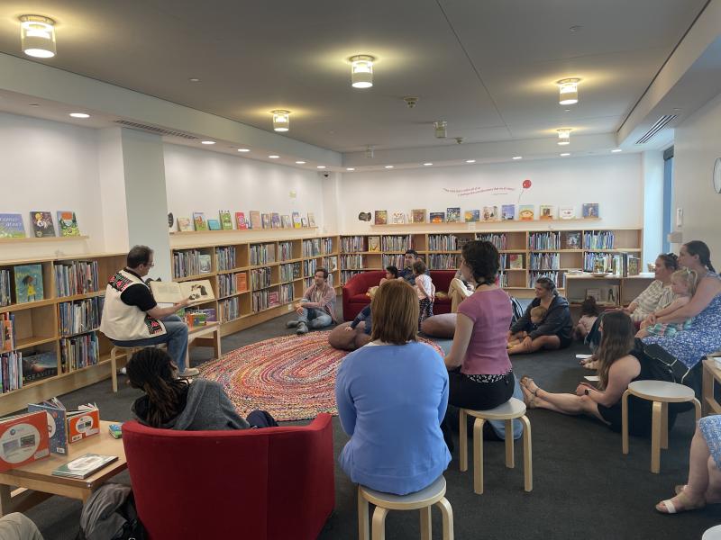 Reading library with people sitting around and Dr. Lee Francis reading a book