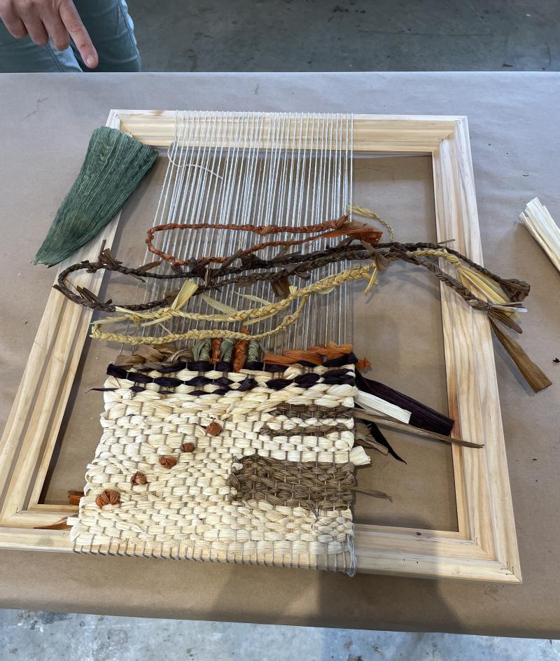 loom with cornhusk weaving in different shades from natural to dark brown and green
