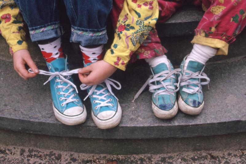 photograph of two pairs of converse sneakers.