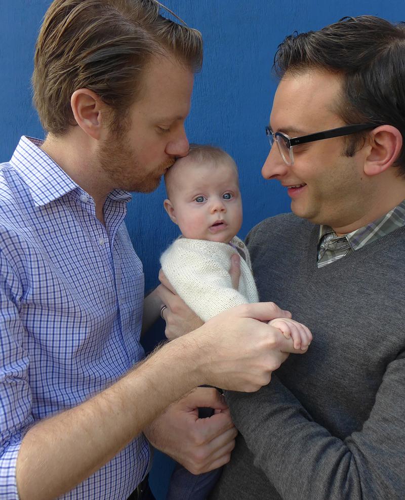 photograph of dads holding baby.