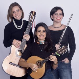 Three musicians smiling and holding instruments.