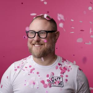 Headshot of Michael Sjostedt, pink paper confetti dots. 