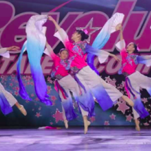 Xi Wang Dance School dancers performing on stage.