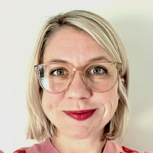 a blonde woman in a sweater with cats on it