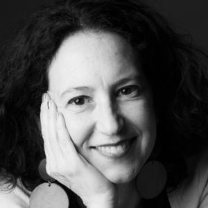 a woman resting her head in her hand, smiling