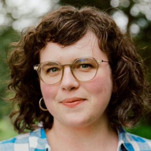 A white woman wearing a checkered shirt.