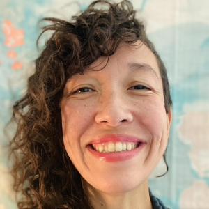 A woman in a blue shirt, smiling