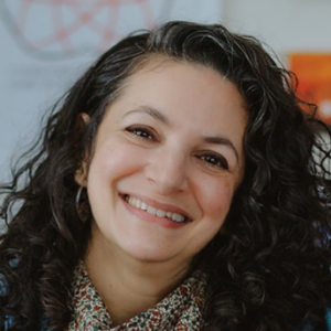 A woman wearing a blue shirt, smiling.
