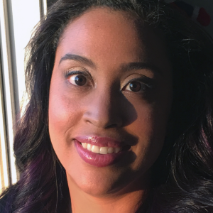 A woman with dark hair, smiling