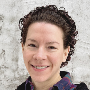 a woman wearing a plaid shirt, smiling