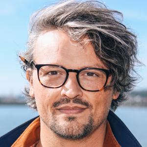 a man in glasses and a striped shirt