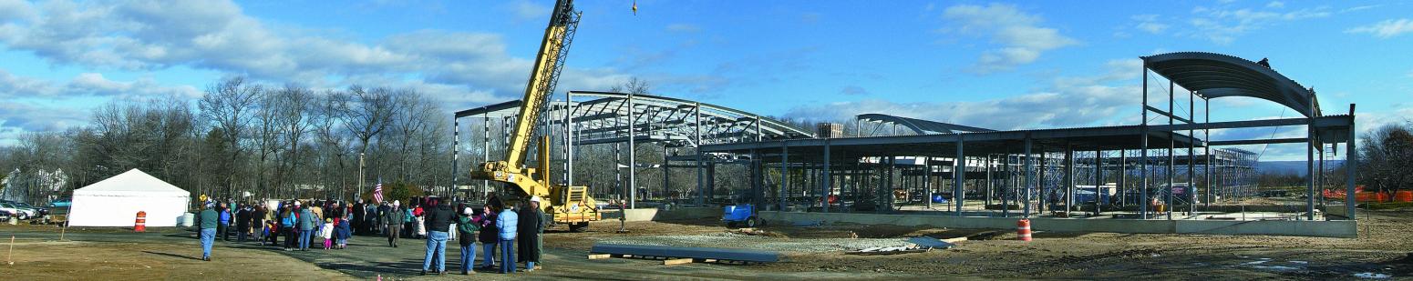 museum construction site with large metal building frame and large yellow crane