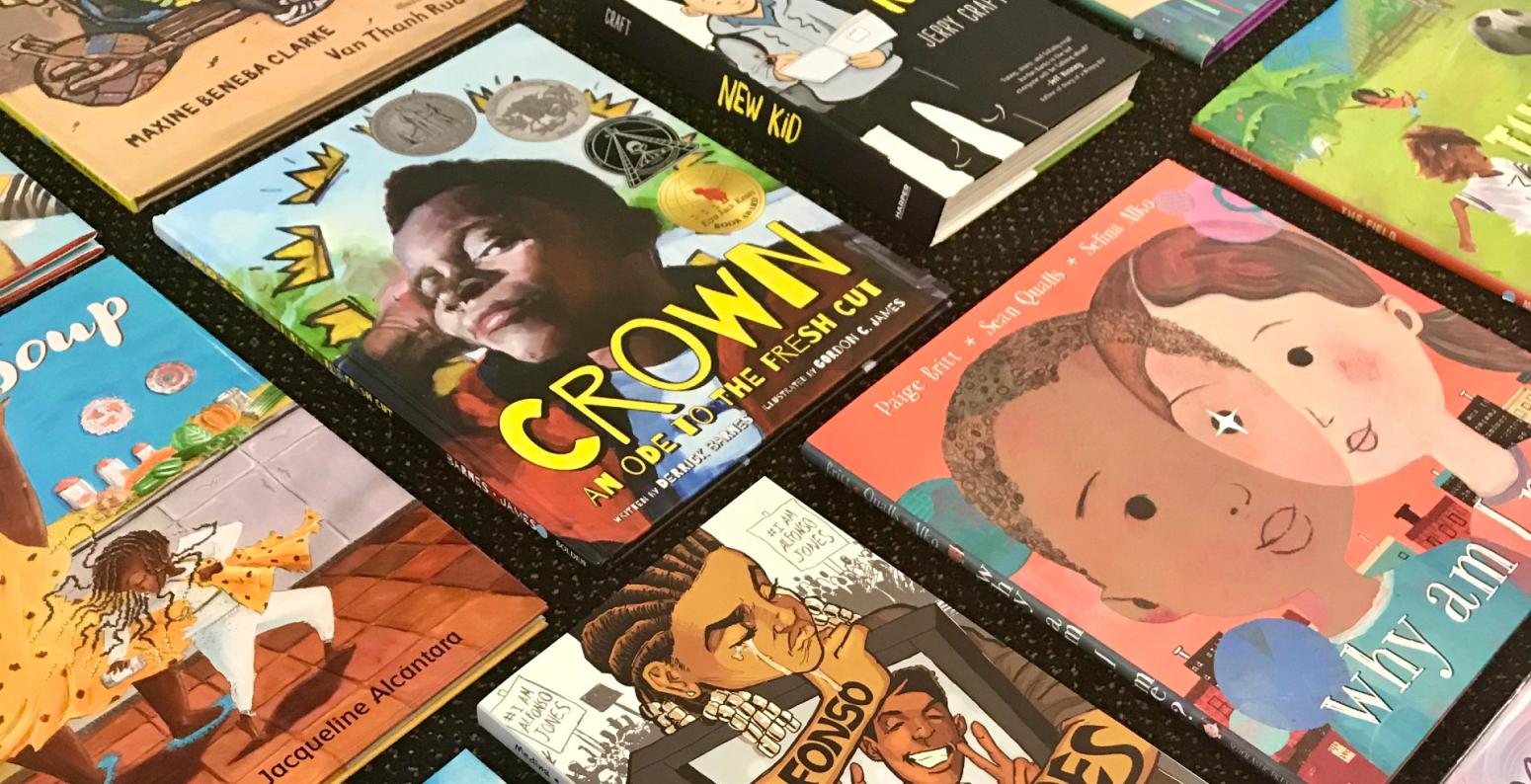 Multiple picture books by Black creators are arranged in a grid on a black background