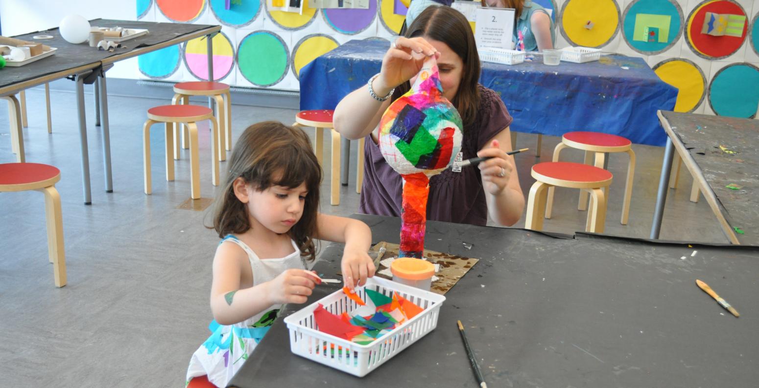 Two people making tissue paper sculptures in the studio.